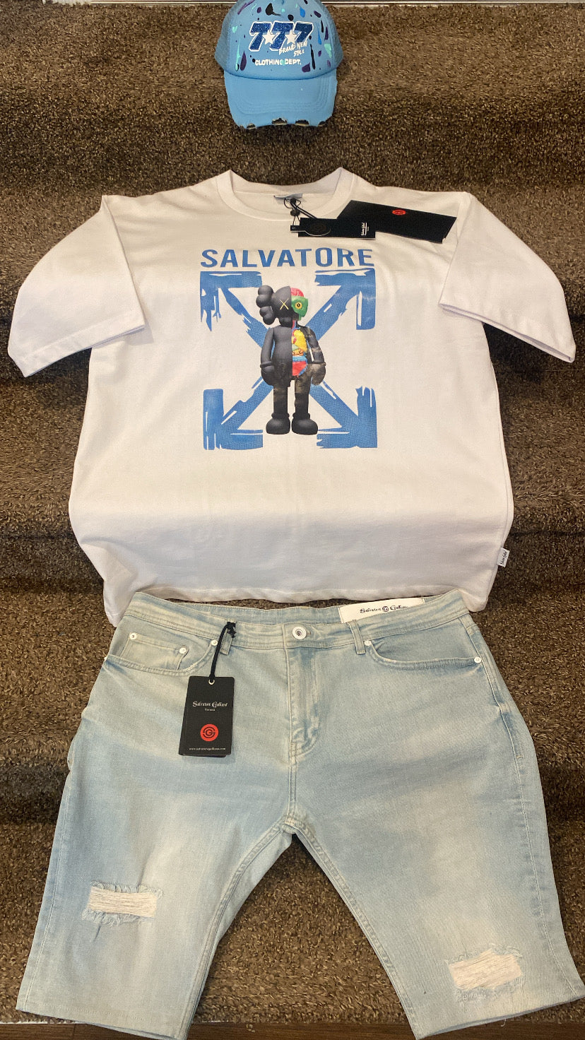 White t-shirt with graphic design, light blue shorts, and blue cap on a brown surface